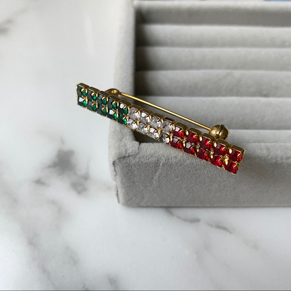 Pave pin brooch with green white red stones